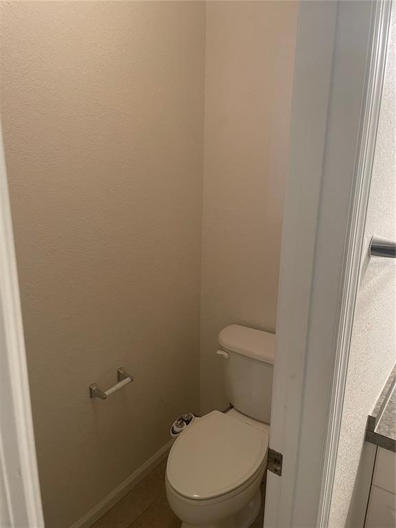 A small, neutral-toned water closet features a white toilet with an attached bidet sprayer — 6233 ASHBURY PALMS DRIVE, TAMPA, FL