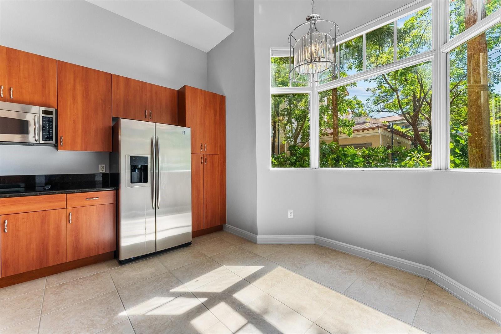 A kitchen with wood cabinets, stainless steel appliances, and a large bay window — 16102 Emerald Estates Drive # 101, Weston FL 33331, WESTON, FL