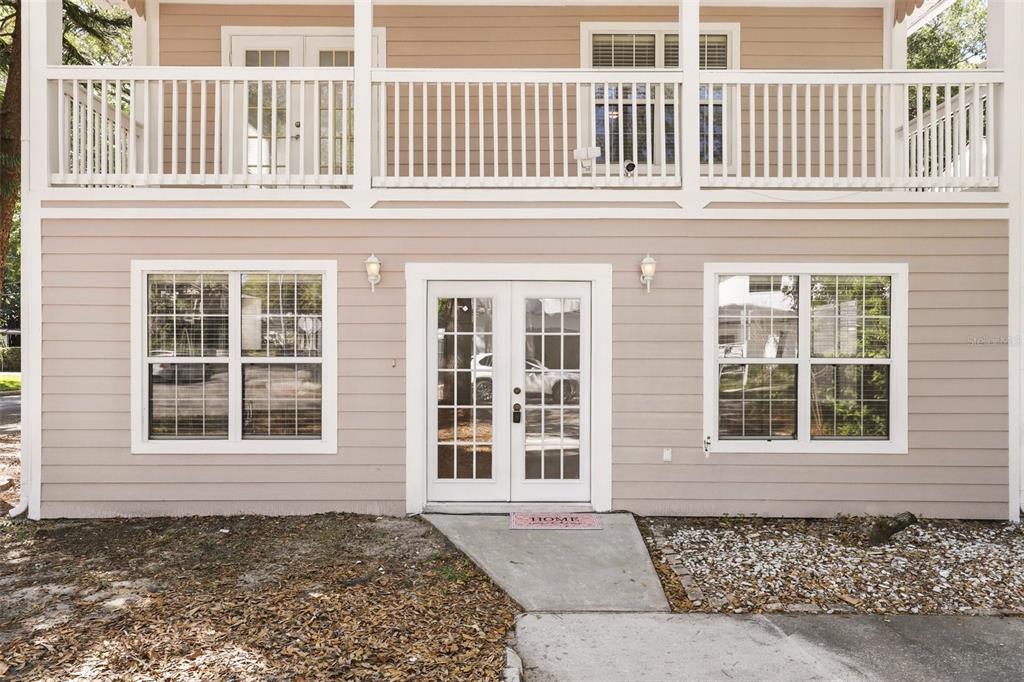 A two-story house exterior features a ground-level entrance with French doors and two windows — 820 ALTALOMA AVENUE, ORLANDO, FL