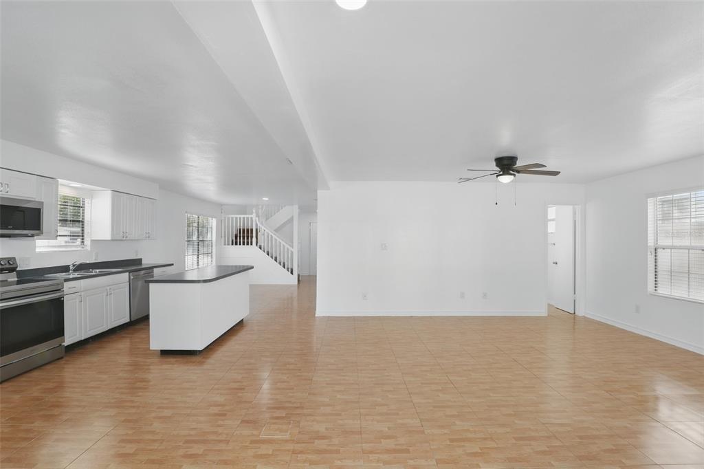 An open-concept kitchen and living area with white cabinets, a kitchen island, and tile flooring — 820 ALTALOMA AVENUE, ORLANDO, FL