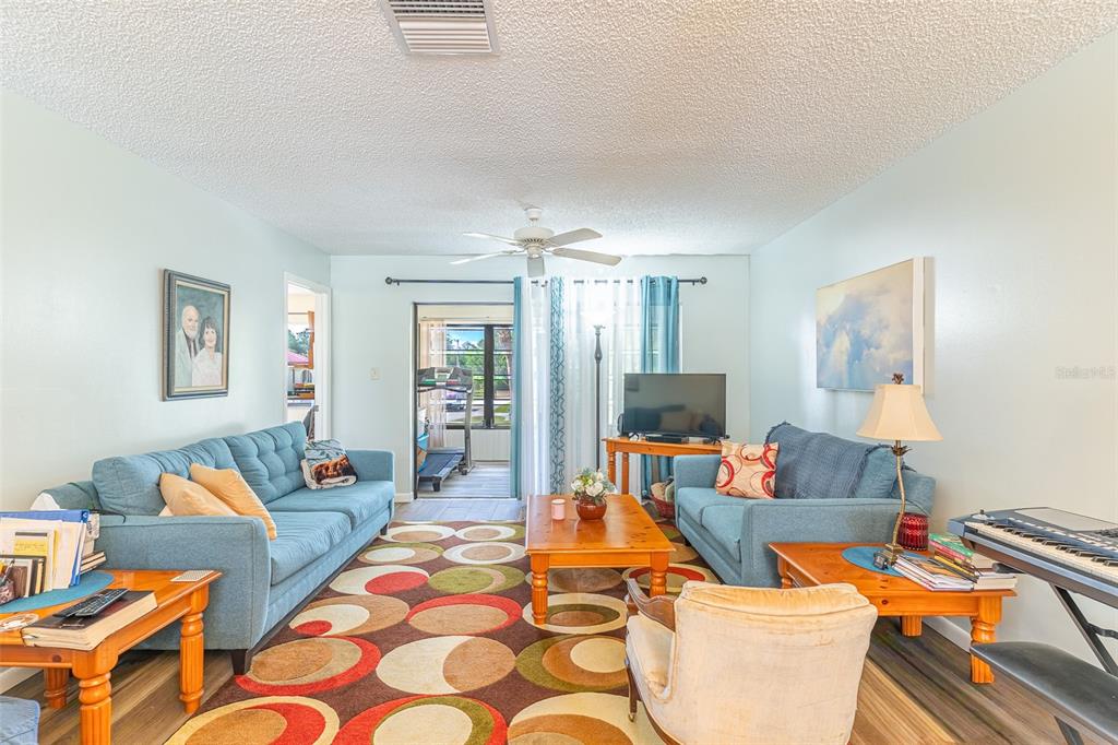 A living room features two blue sofas, a patterned rug, and a wooden coffee table — 3007 GRANADA COURT UNIT 4, LAKE WALES, FL