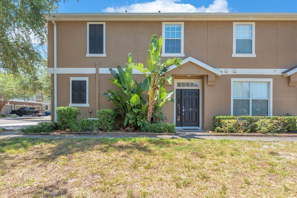 A two-story tan townhouse exterior features a front entrance, a large plant, and windows — 7001 INTERBAY BOULEVARD UNIT 259, TAMPA, FL