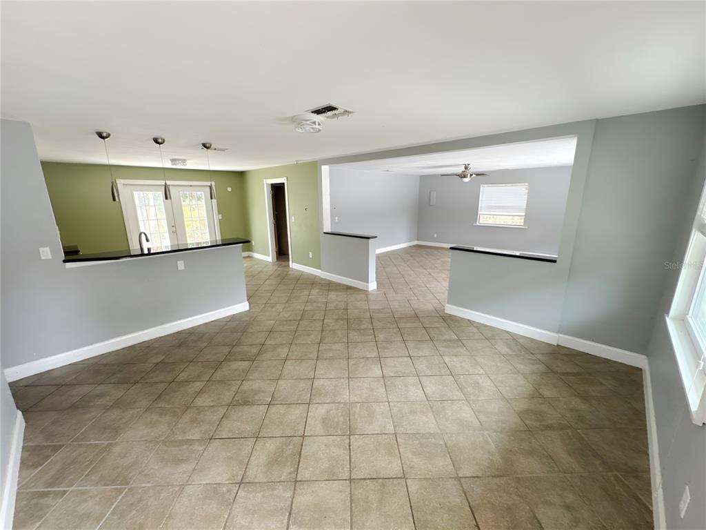 A tiled living area features a kitchen breakfast bar and an open-concept sunken room — 4710 HOXIE LANE, SARASOTA, FL