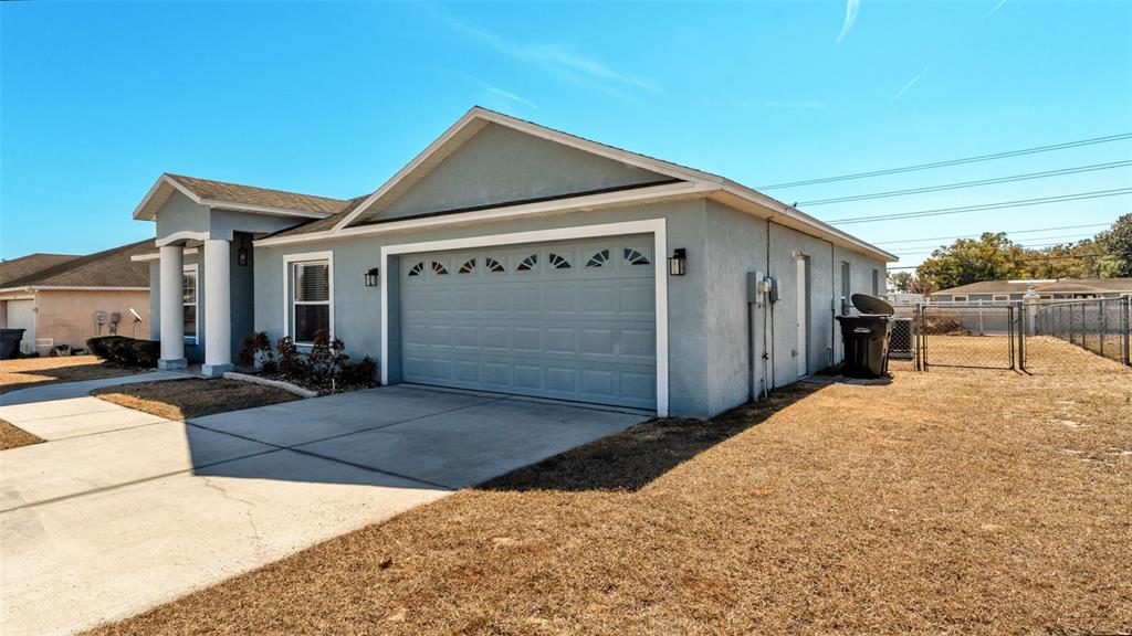 A light blue single-story house with a two-car garage and a concrete driveway — 6146 MISSION DRIVE, LAKELAND, FL