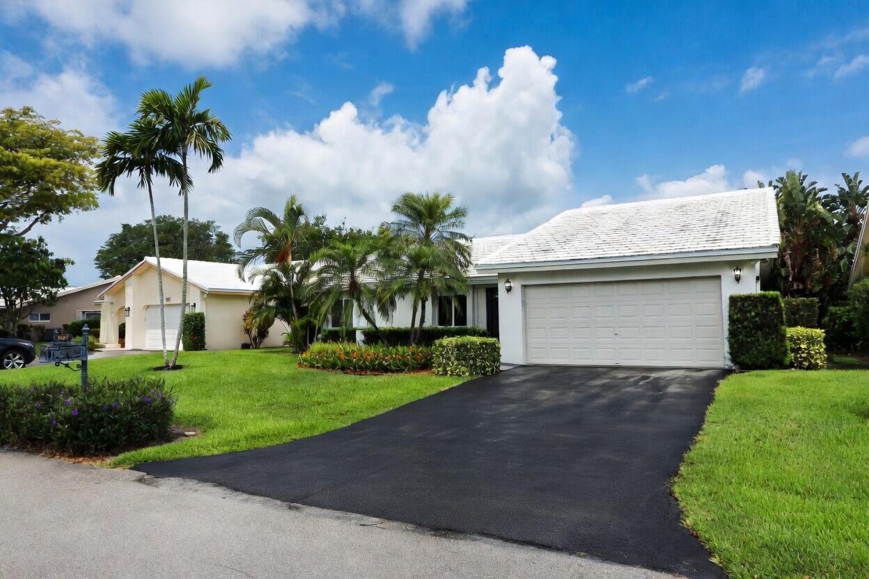 A single-story house with a white roof, a two-car garage, and palm trees in front — 5667 Cameo Drive N, Boca Raton FL 33433, BOCA RATON, FL