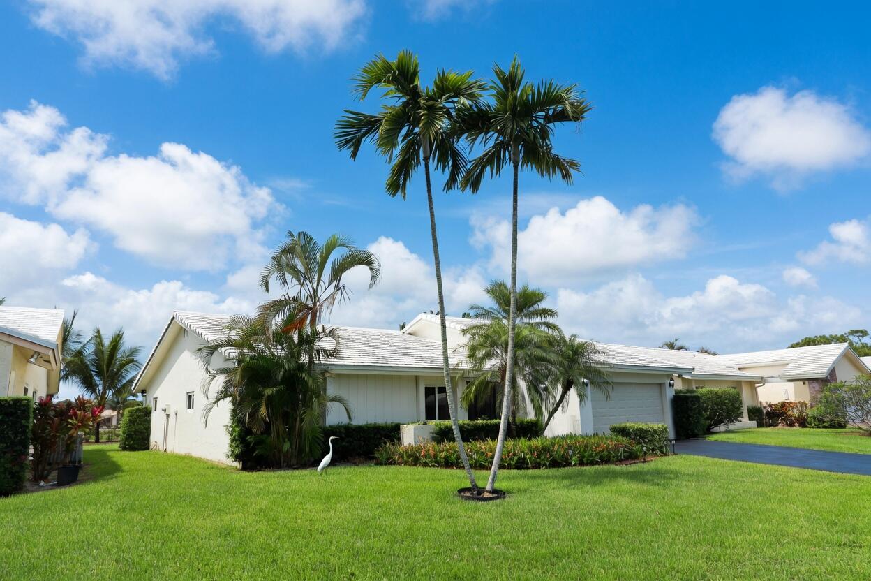 A single-story house with a white roof and palm trees on a grassy lawn — 5667 Cameo Drive N, Boca Raton FL 33433, BOCA RATON, FL