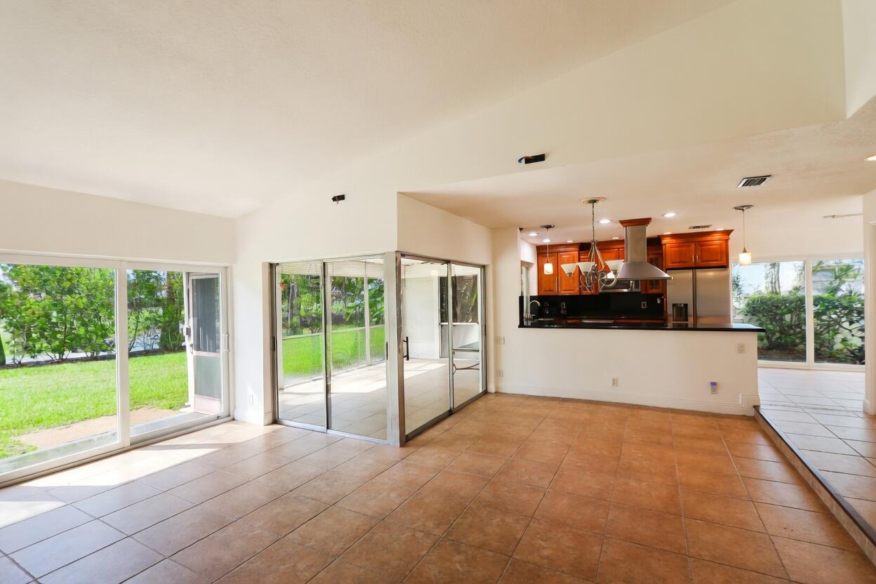 A tiled living area opens to a kitchen with wood cabinets and a screened patio — 5667 Cameo Drive N, Boca Raton FL 33433, BOCA RATON, FL