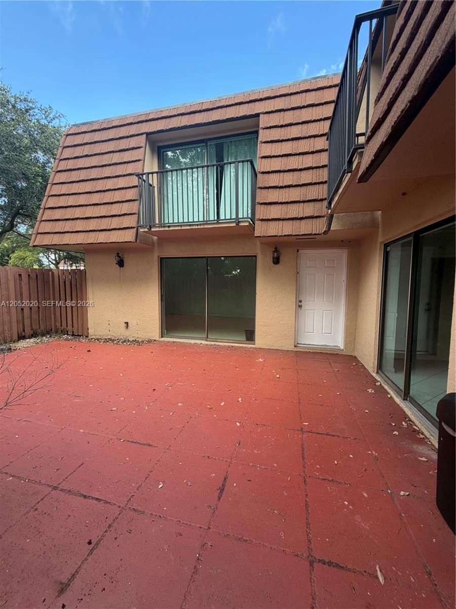 A two-story building features a red concrete patio, sliding glass doors, and a small balcony — 2563 CAMELOT # 2563, Cooper City FL 33026, COOPER CITY, FL