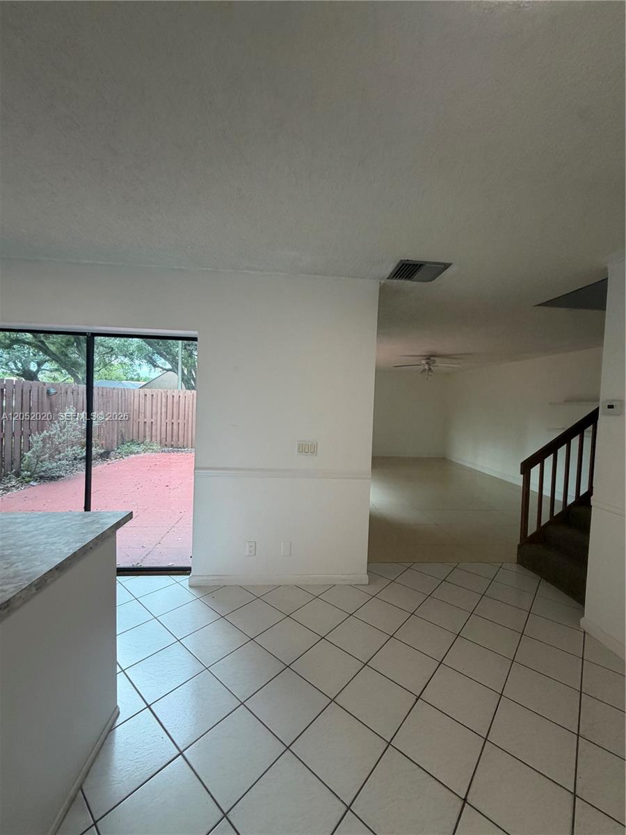 A tiled kitchen area opens to a living room with stairs and a sliding glass door — 2563 CAMELOT # 2563, Cooper City FL 33026, COOPER CITY, FL