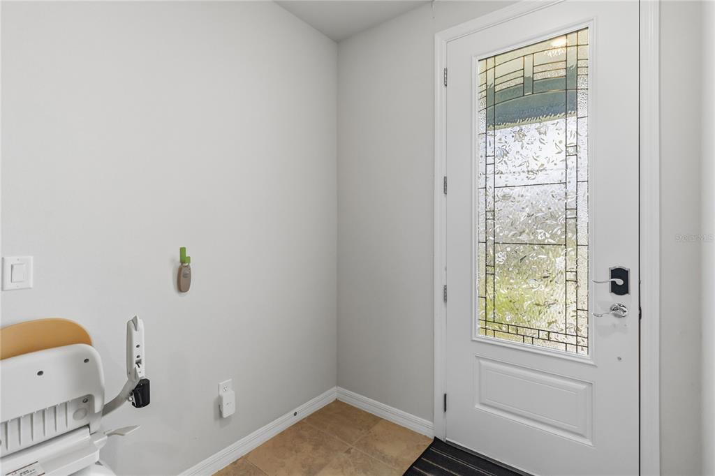 An entryway features light gray walls, tile flooring, and a white door with decorative glass — 6910 REVERIE PARK AVE STREET, ORLANDO, FL