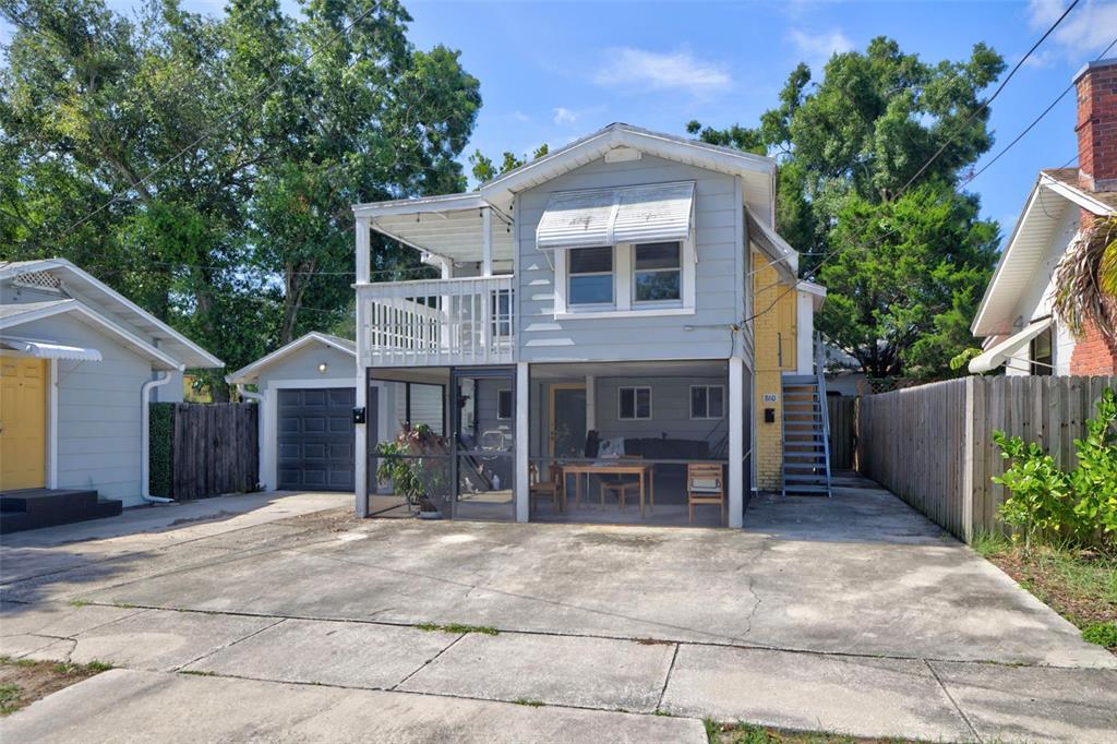 A two-story house with a screened-in ground floor, an upper deck, and a concrete driveway — 860 12TH AVENUE N, ST PETERSBURG, FL