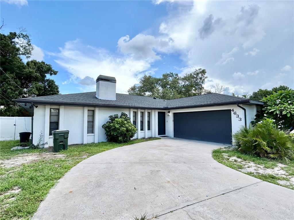 A single-story house with a white exterior, dark roof, and a two-car garage — 4633 BROOKSDALE DRIVE, SARASOTA, FL