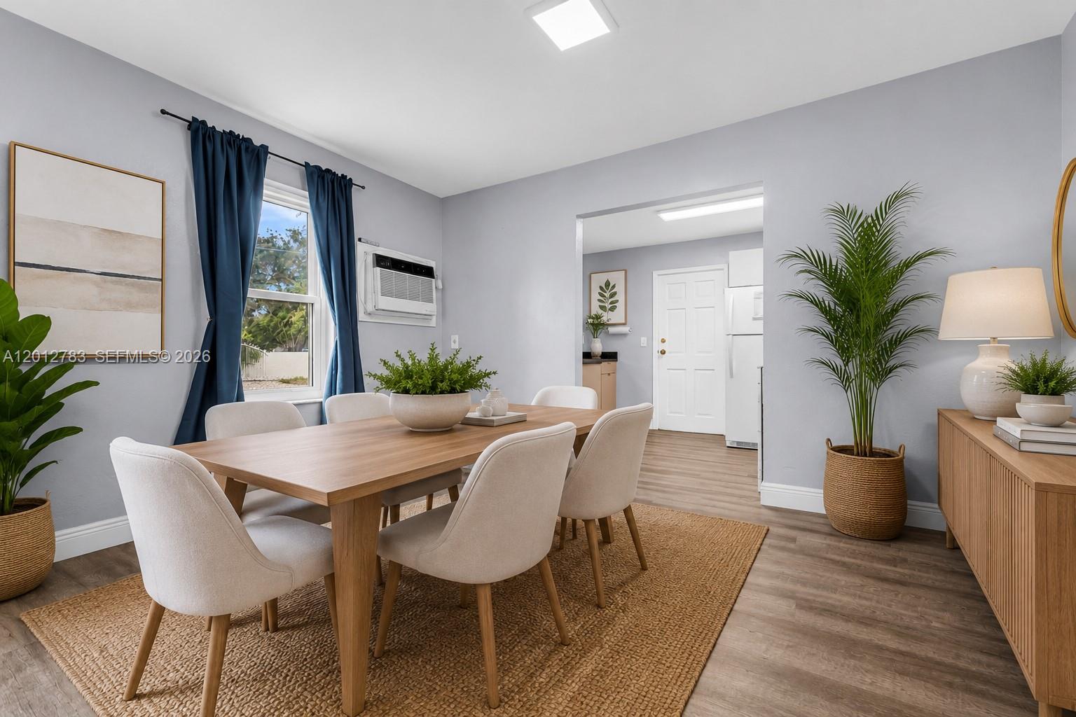 A dining room features a wooden table, light-colored chairs, a rug, and a side cabinet — 9301 NW 20th Ave, Miami FL 33147, MIAMI, FL