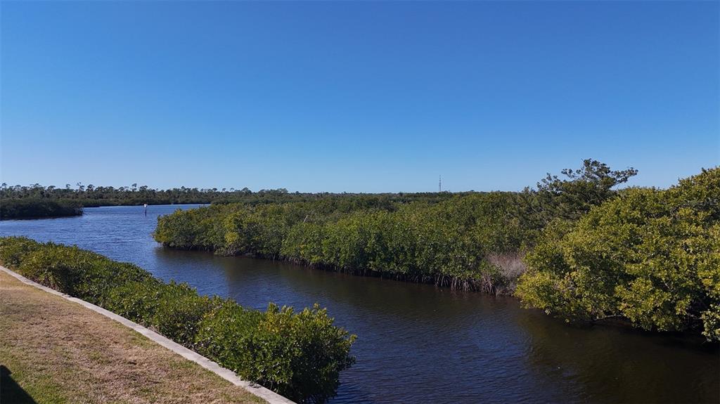 A view of a narrow waterway winding through dense green mangroves under a clear sky — 732 BLACKBURN BOULEVARD, NORTH PORT, FL