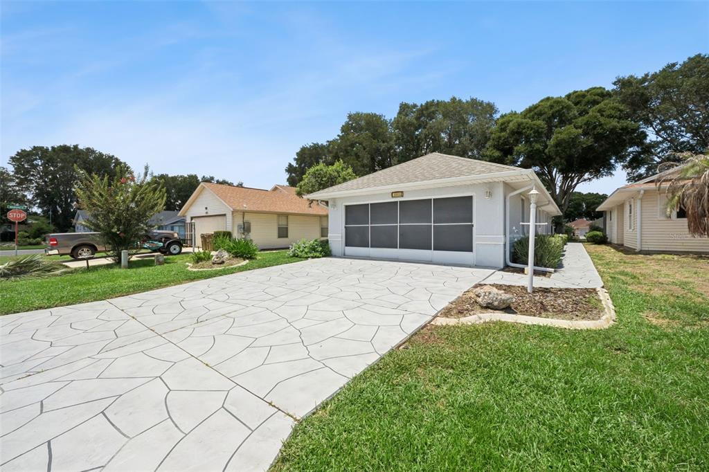 A single-story house with a screened garage door and a decorative concrete driveway — 5503 LAVER STREET, LEESBURG, FL