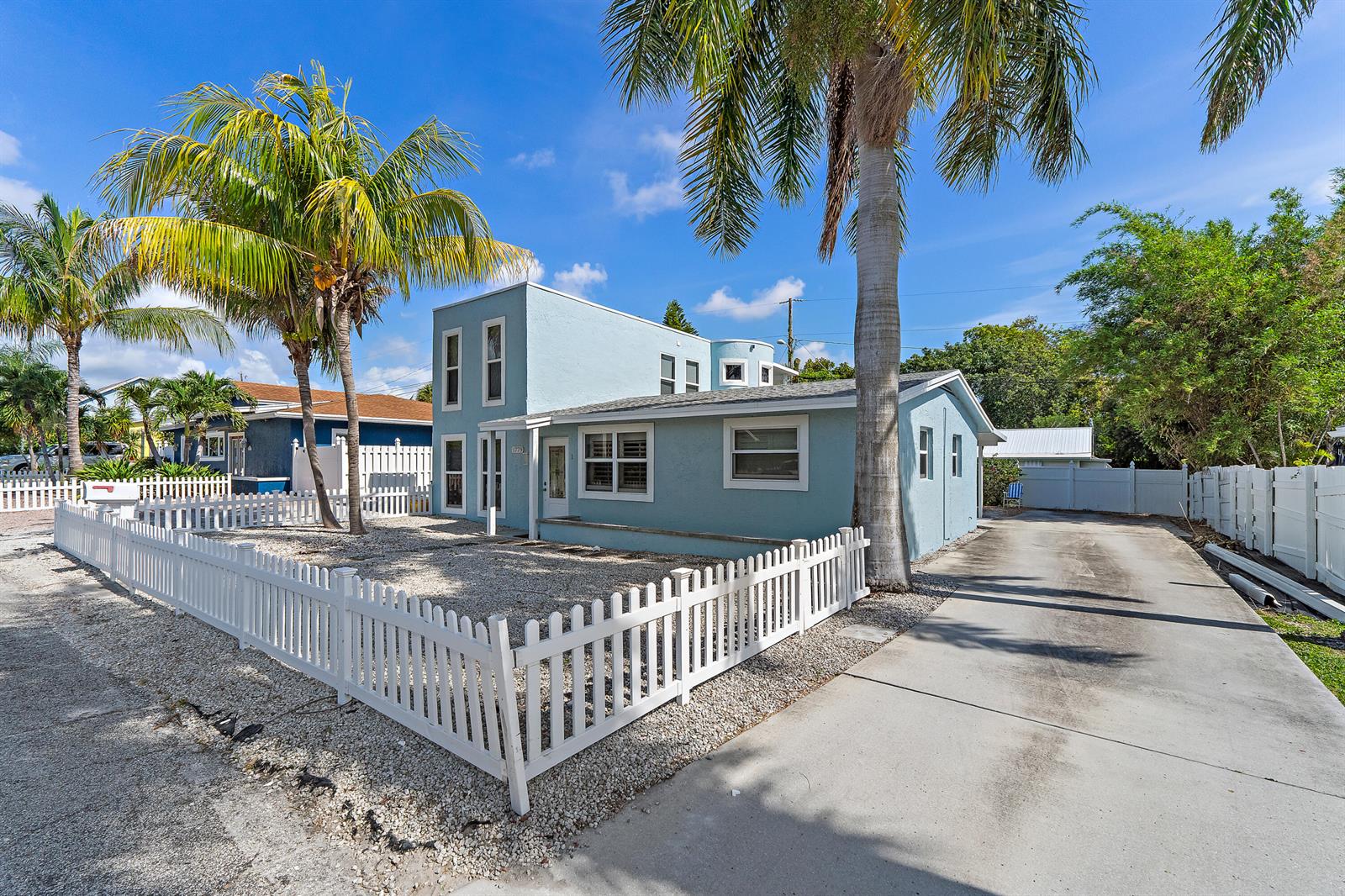 A light blue two-story house features a white picket fence and a concrete driveway — 1779 Len Drive # 1, North Palm Beach FL 33408, NORTH PALM BEACH, FL