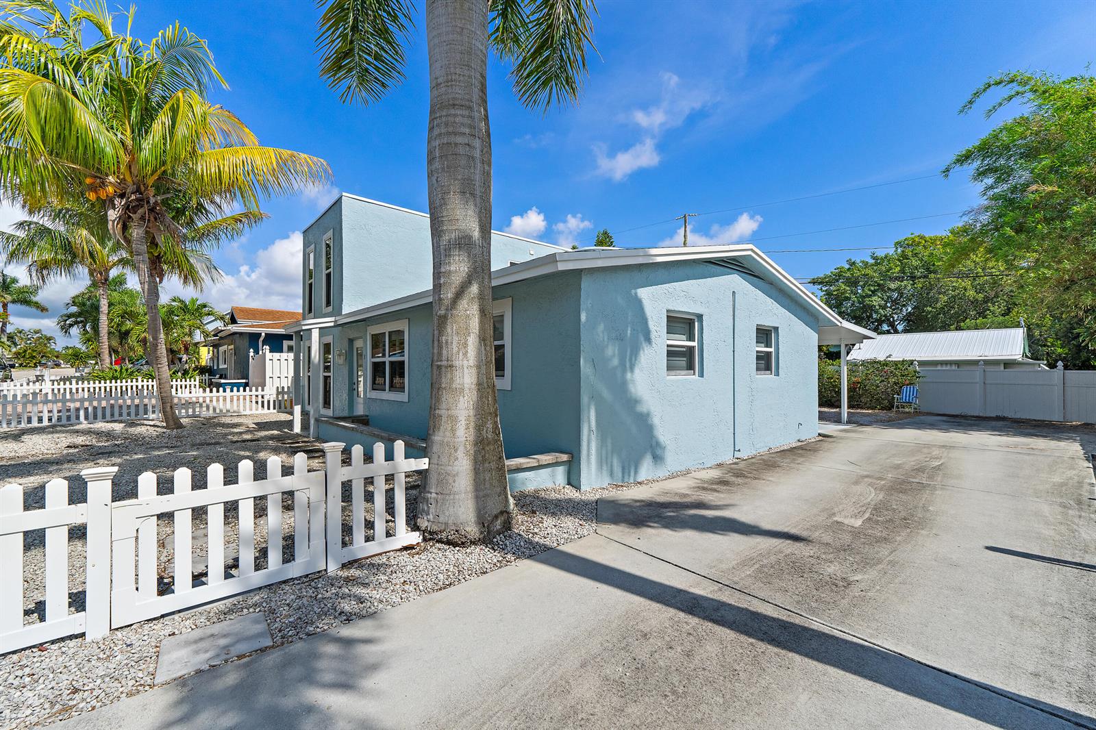 A light blue house with a white picket fence and a palm tree in front — 1779 Len Drive # 1, North Palm Beach FL 33408, NORTH PALM BEACH, FL