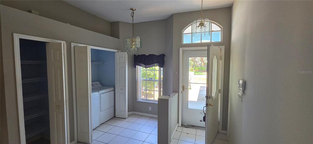 An entryway features a tiled floor, a laundry closet, a storage closet, and a front door — 12519 HOLLYBROOK LANE, HUDSON, FL