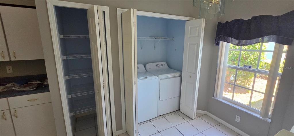 A room features a pantry with wire shelving, a laundry closet, and a window — 12519 HOLLYBROOK LANE, HUDSON, FL