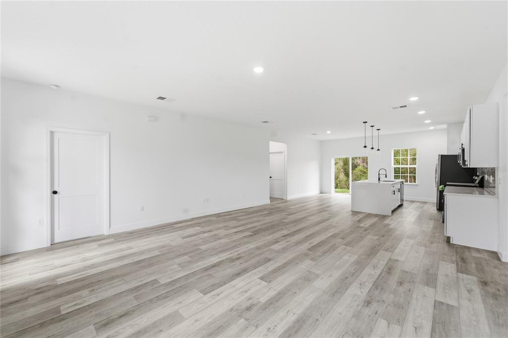 A modern kitchen with white cabinets, a central island, and an adjacent dining area — 2773 SW 147ST STREET RD, OCALA, FL
