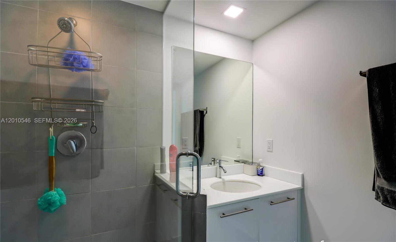 A bathroom features a glass-enclosed shower with gray tile and a white vanity with mirror — 92 SW 3rd St # 2410, Miami FL 33130, MIAMI, FL