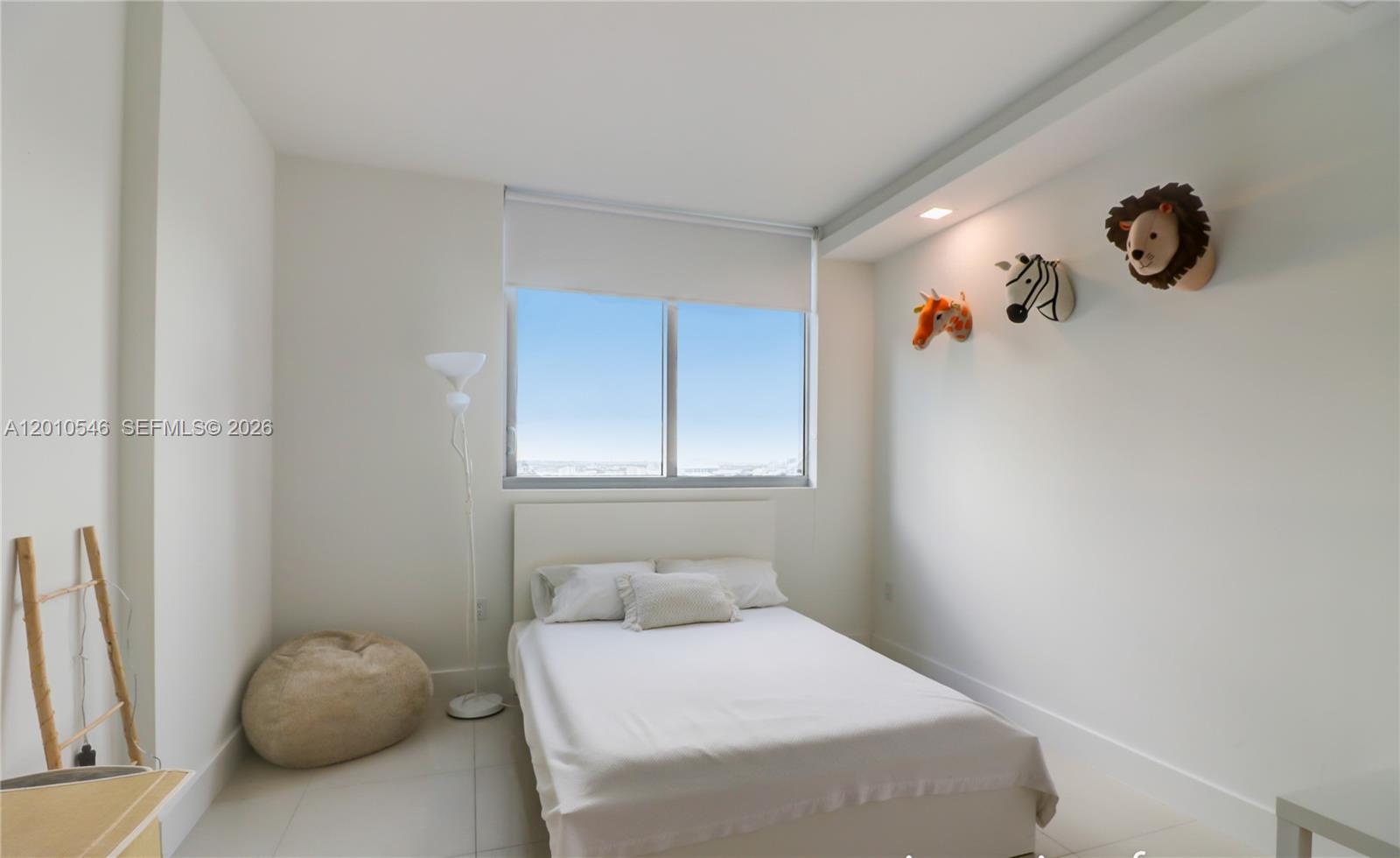 A bedroom features a white bed, a floor lamp, and three plush animal wall mounts — 92 SW 3rd St # 2410, Miami FL 33130, MIAMI, FL