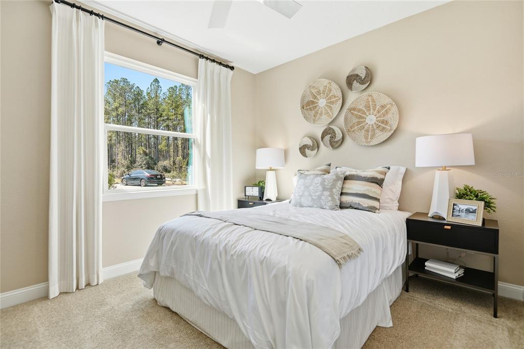 A bedroom features a bed with white bedding, two nightstands, and wall-mounted woven decor — 2530 29TH LANE E, PALMETTO, FL