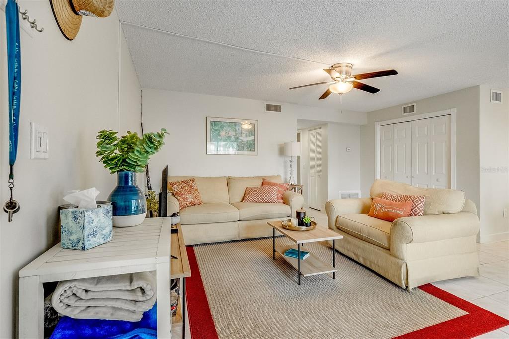 A living room and dining area with light green walls, tile floors, and neutral furniture — 200 INTERNATIONAL DRIVE UNIT 505, CAPE CANAVERAL, FL