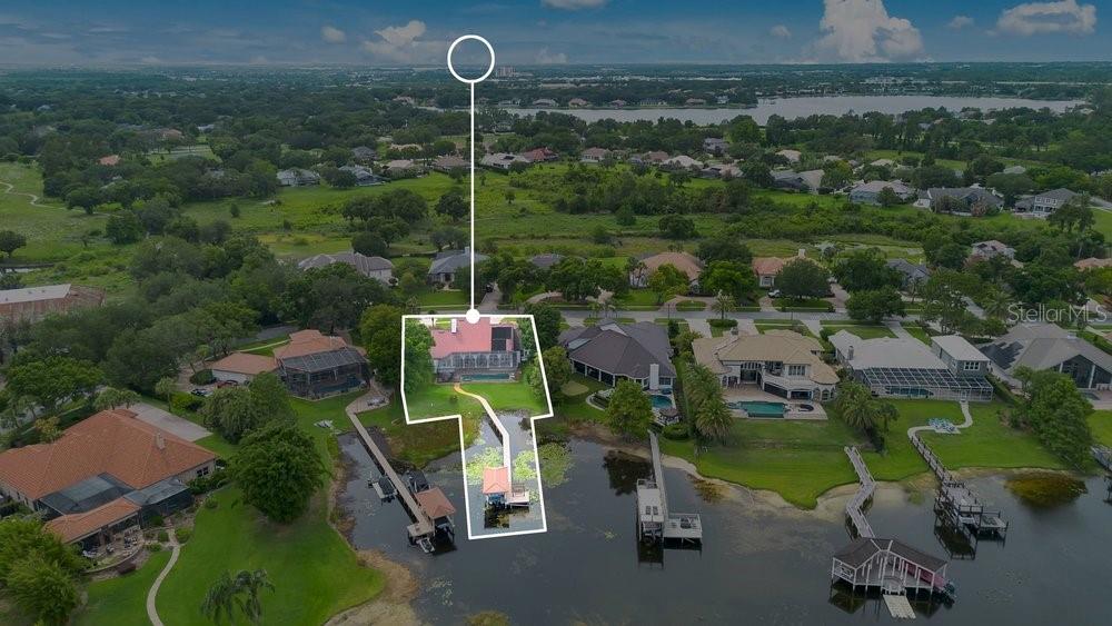 An aerial view shows a waterfront house with a private dock and a swimming pool — 2503 BUTLER BAY DRIVE N, WINDERMERE, FL