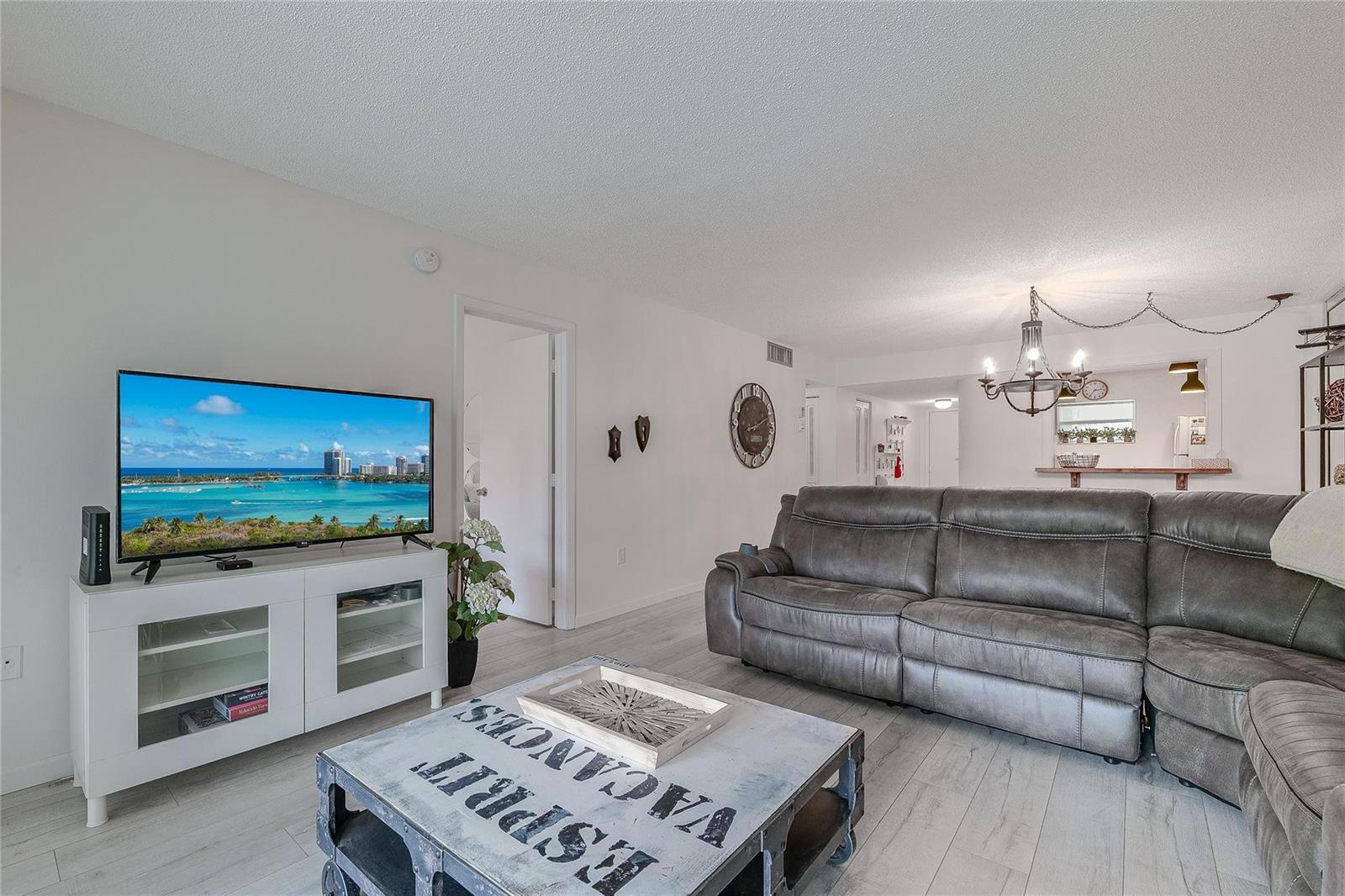 A living room features a gray sectional sofa, a white media console, and a coffee table — 3920 Inverrary Boulevard # C, Lauderhill FL 33319, LAUDERHILL, FL