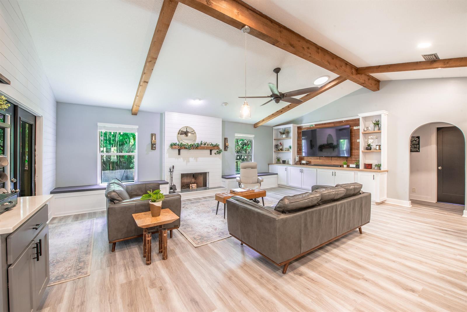 A spacious living room features vaulted ceilings with wood beams, a fireplace, and built-in shelving — 12970 179th Ct N, Jupiter FL 33478, JUPITER, FL
