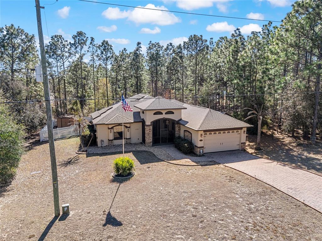 An aerial view shows a single-story house with a paved driveway and a flag pole — 1198 W CITRUS SPRINGS BOULEVARD, CITRUS SPRINGS, FL
