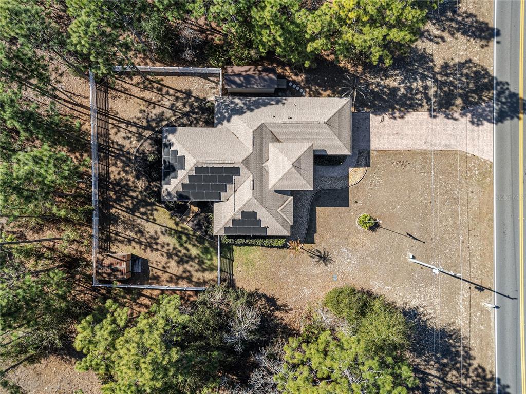 An aerial view shows a house with solar panels on the roof and a fenced yard — 1198 W CITRUS SPRINGS BOULEVARD, CITRUS SPRINGS, FL