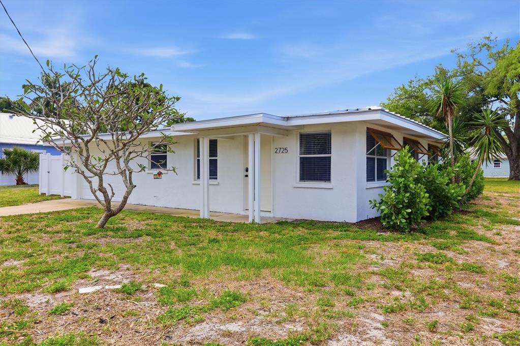 A single-story white house with a flat roof and a small covered entryway — 301 28TH STREET W, BRADENTON, FL
