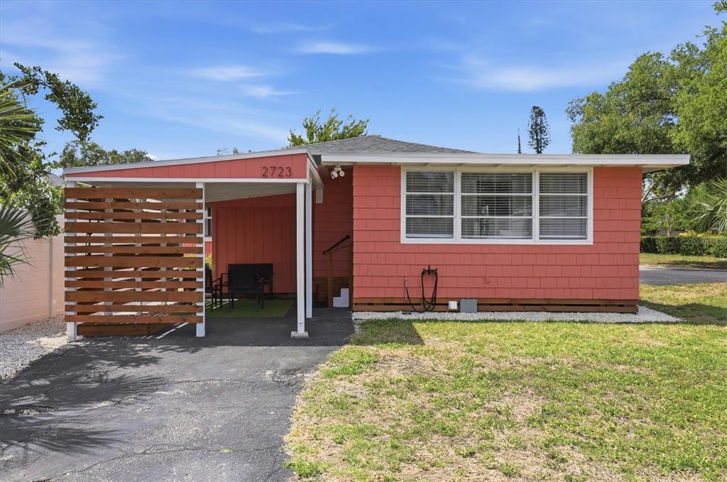A single-story house with salmon-colored shingles, a carport, and a wooden privacy screen — 301 28TH STREET W, BRADENTON, FL