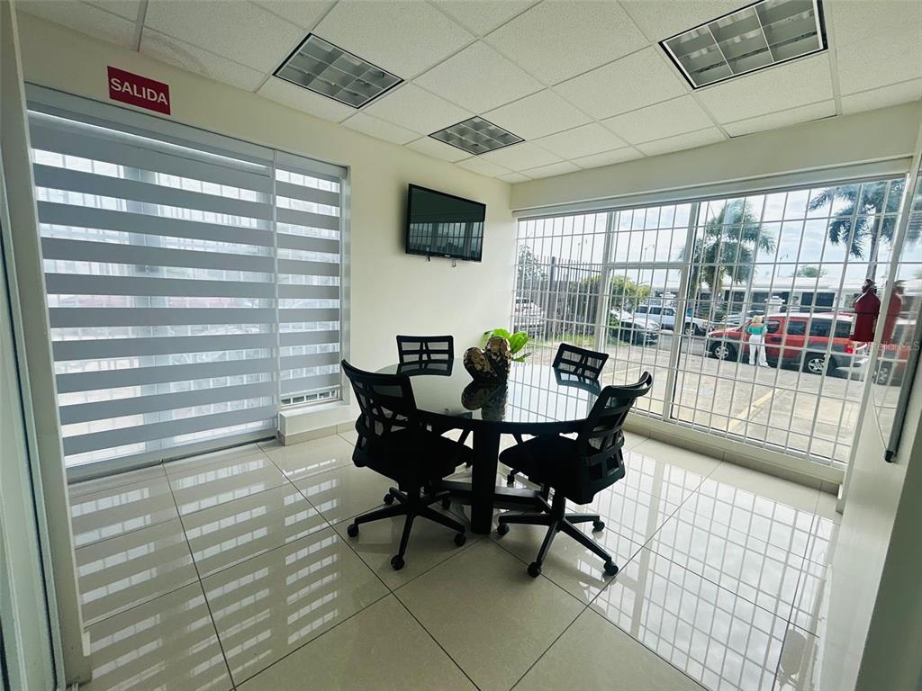 A small office space features a glass table, black chairs, tiled floors, and large windows — 1396 CALLE BONITA, PONCE, PR