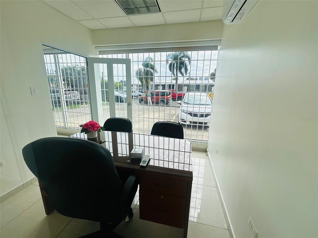 An office with a desk, two chairs, and a window overlooking a parking lot — 1396 CALLE BONITA, PONCE, PR