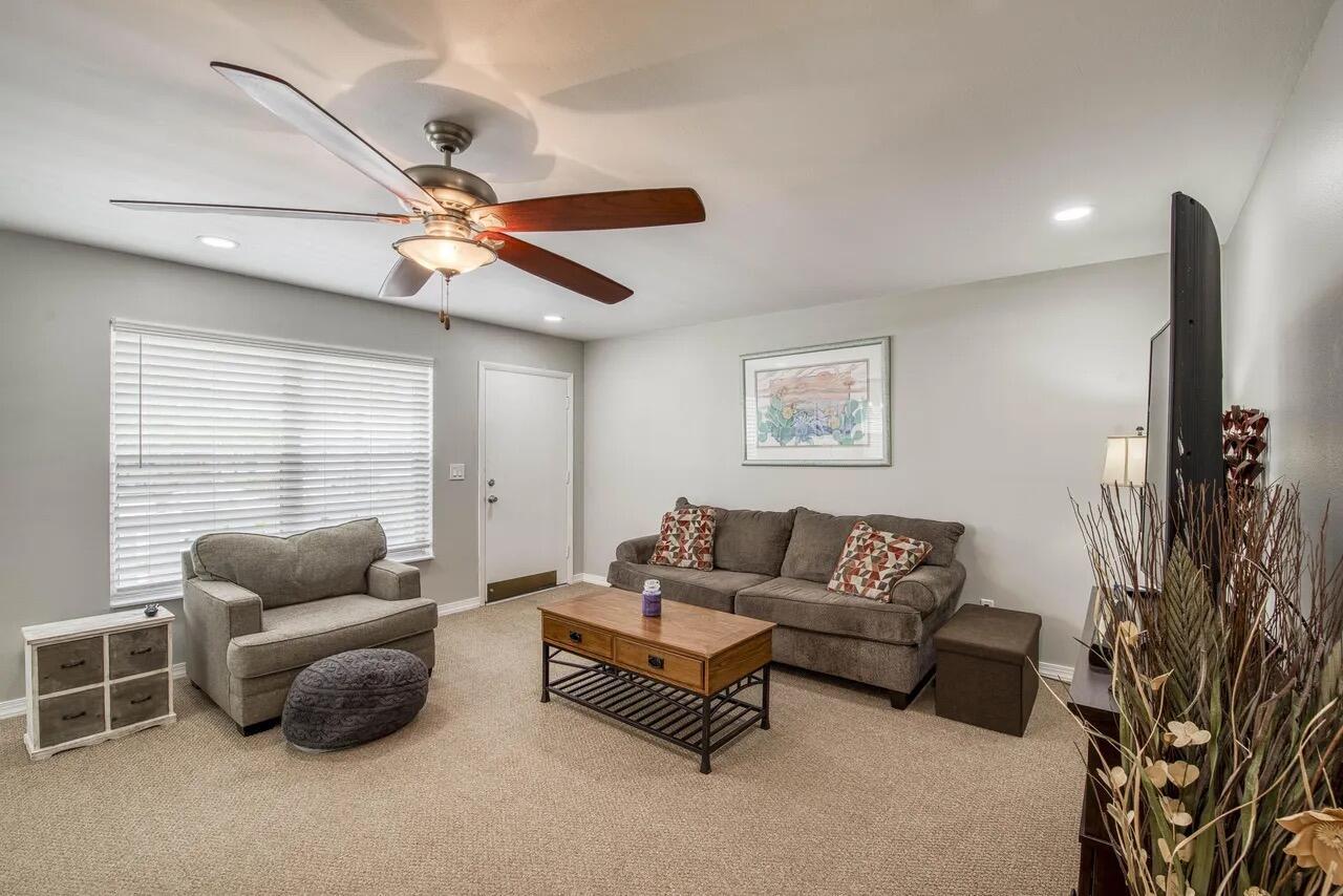 A living room features a ceiling fan, gray sofa, armchair, coffee table, and carpeted flooring — 2929 SE Ocean Boulevard # 6, Stuart FL 34996, STUART, FL