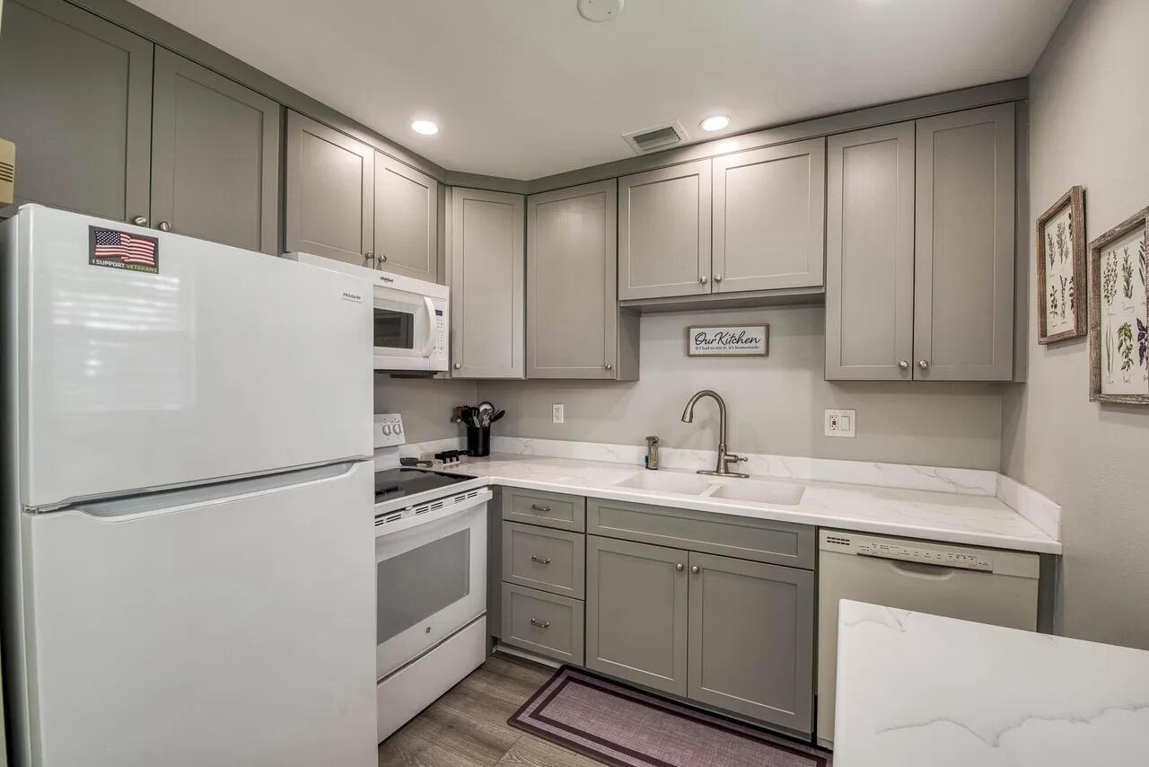 A kitchen features gray cabinets, white appliances, a white countertop, and a double-basin sink — 2929 SE Ocean Boulevard # 6, Stuart FL 34996, STUART, FL