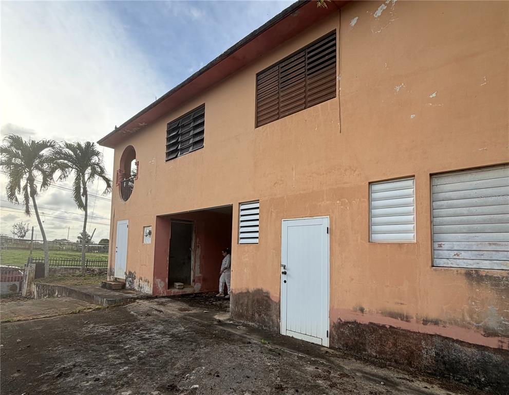 The exterior of a two-story peach-colored building with louvered windows and a ground-level entryway — 492 BO. CORCOVADO, HATILLO, PR