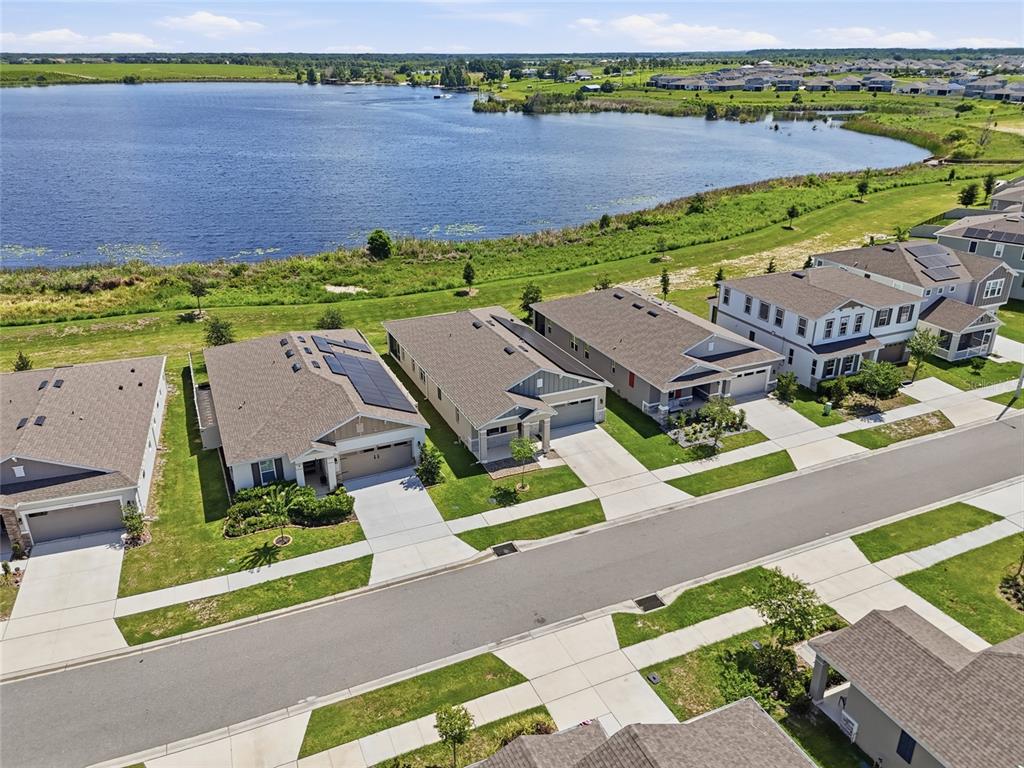 An aerial view shows a row of suburban houses situated along a large lake — 984 GRIFFON AVENUE, LAKE ALFRED, FL