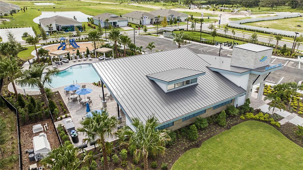 An aerial view shows a community clubhouse with a pool, playground, and parking lot — 12447 49TH STREET E, PARRISH, FL