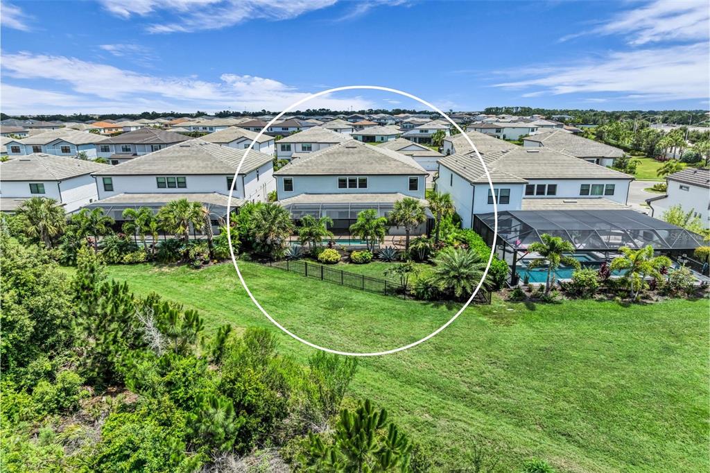 An aerial view shows the back of a two-story house with a screened-in pool — 16438 SLATE PLACE, LAKEWOOD RANCH, FL