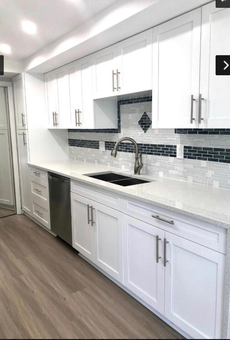 A kitchen with white shaker cabinets, a dark tile backsplash, and light-colored quartz countertops — 859 Jeffery Street # 311, Boca Raton FL 33487, BOCA RATON, FL