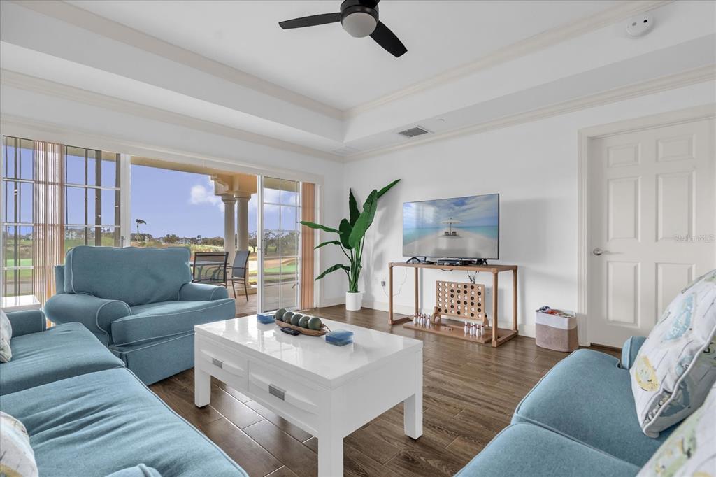 A living room with blue sofas, a white coffee table, and a sliding door view — 1362 CENTRE COURT RIDGE DRIVE UNIT 102, REUNION, FL