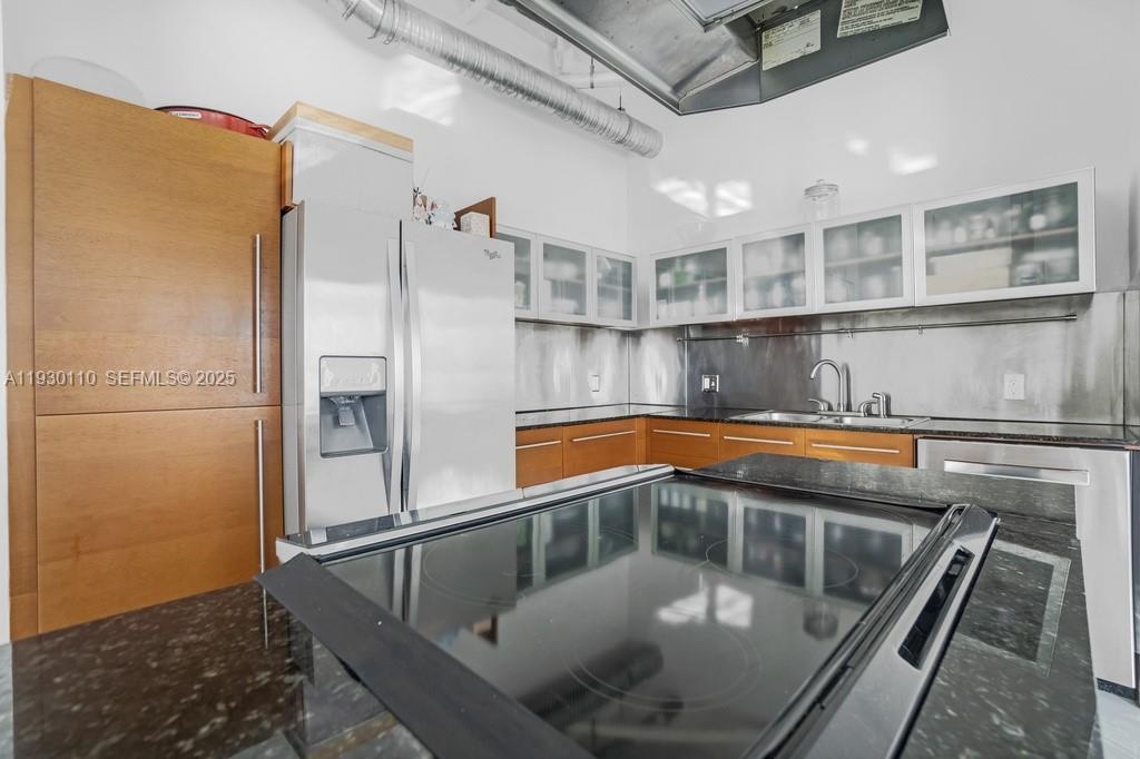 A modern kitchen features wood cabinets, stainless steel appliances, and a black countertop island — 10 SW South River Dr # 608, Miami FL 33130, MIAMI, FL