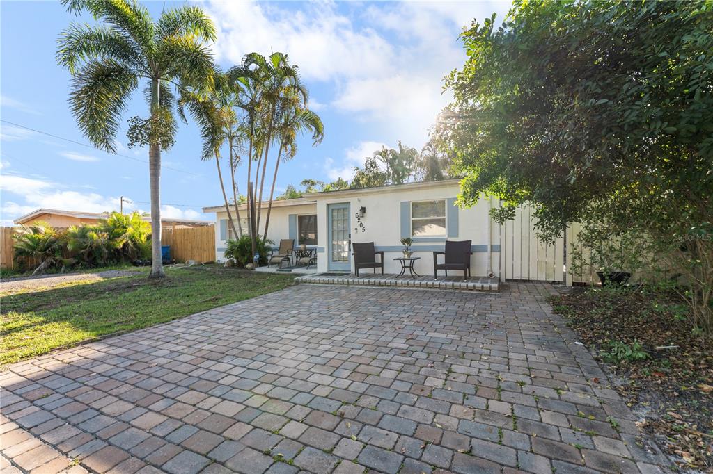 A single-story house with a paved driveway, palm trees, and a small front patio — 6205 65TH STREET N, PINELLAS PARK, FL