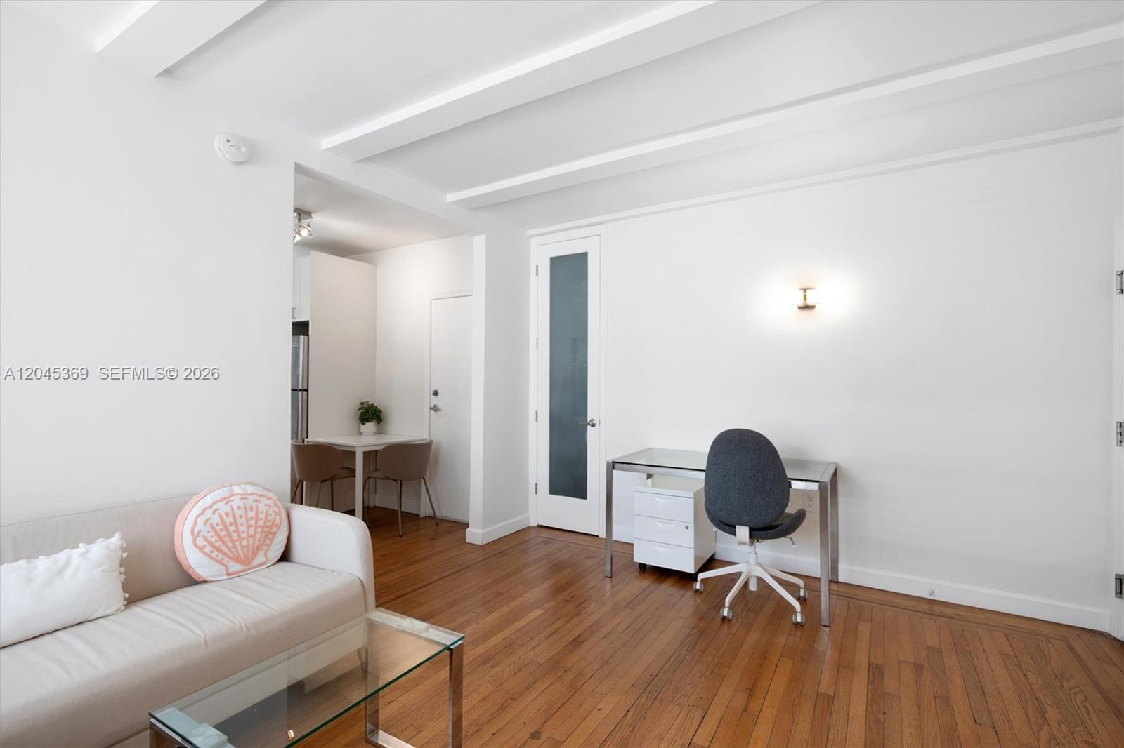 A living room features white walls, hardwood floors, a desk, and a small dining area — 439 15th St # 8, Miami Beach FL 33139, MIAMI BEACH, FL