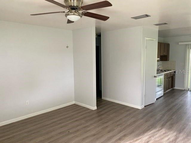 A living area with light gray walls, wood-look flooring, and a ceiling fan — 4808 20TH STREET, ZEPHYRHILLS, FL