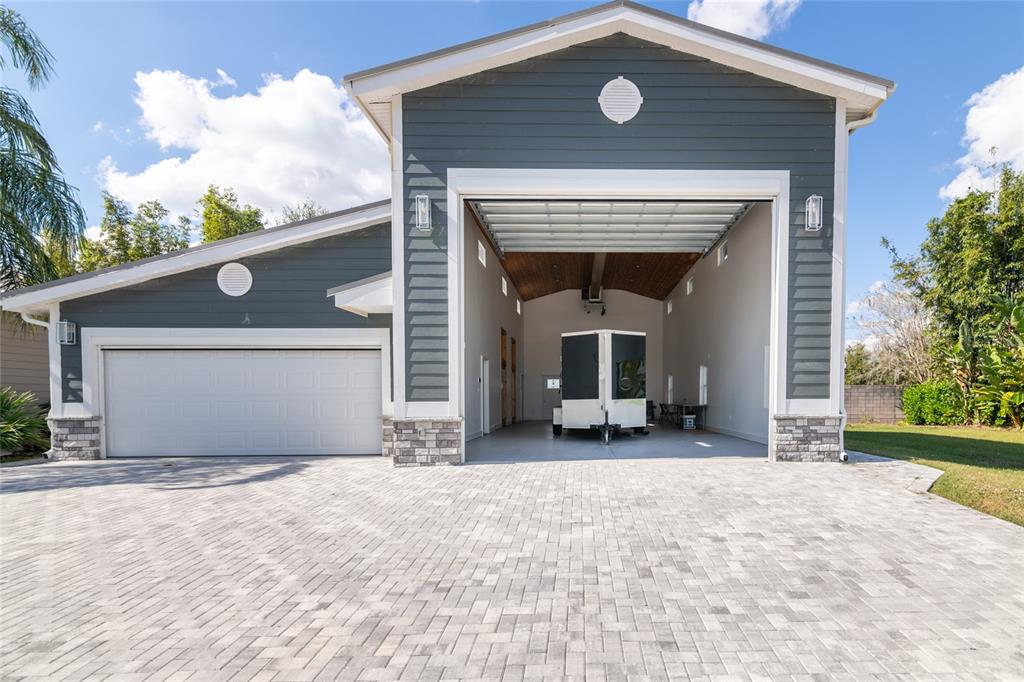 A detached garage with a standard door and a large open bay housing a trailer — 6757 AMANDA VISTA CIRCLE, LAND O LAKES, FL